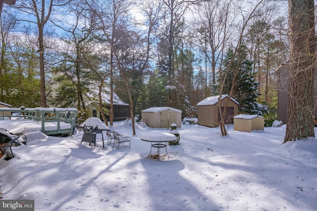 yard covered in snow featuring a storage unit