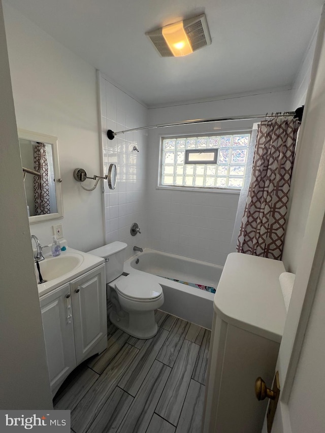 full bathroom with shower / bath combination with curtain, vanity, and toilet