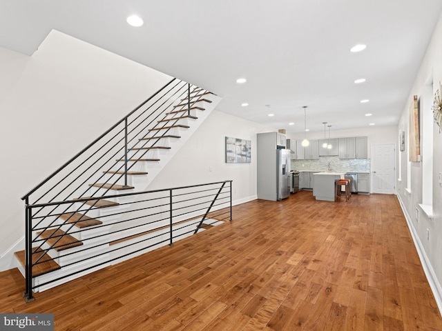 unfurnished living room with sink and light hardwood / wood-style floors