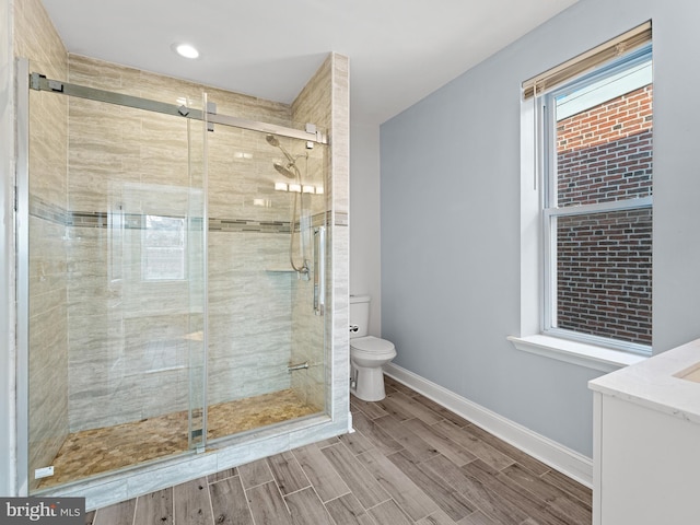 bathroom with vanity, toilet, and a shower with door