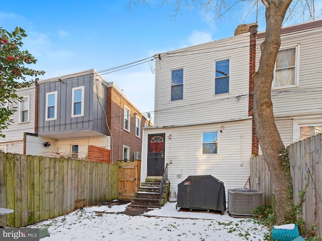 snow covered house with central AC