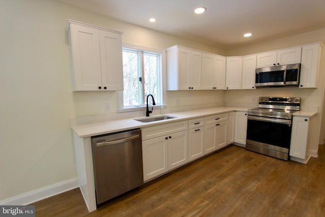 kitchen featuring dark hardwood / wood-style flooring, sink, white cabinetry, and stainless steel appliances