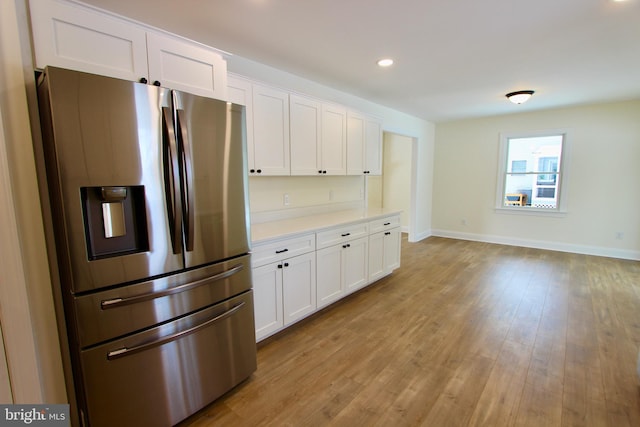 kitchen featuring white cabinetry, light hardwood / wood-style floors, and stainless steel refrigerator with ice dispenser