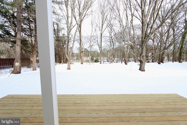 yard covered in snow with a deck