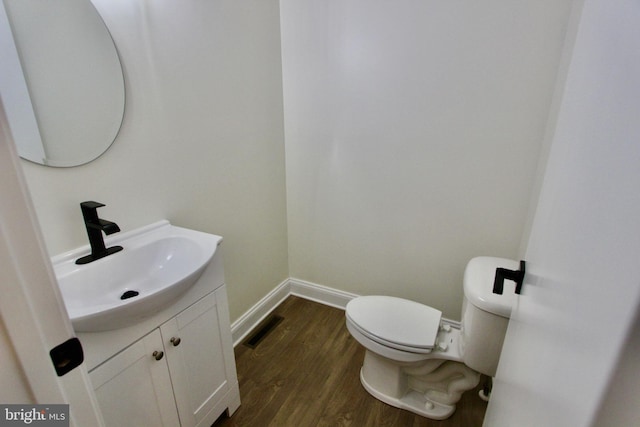 bathroom featuring toilet, vanity, and hardwood / wood-style flooring