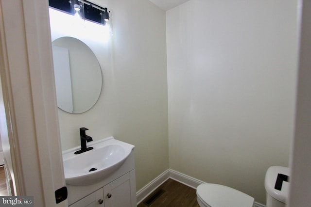 bathroom featuring vanity, hardwood / wood-style flooring, and toilet