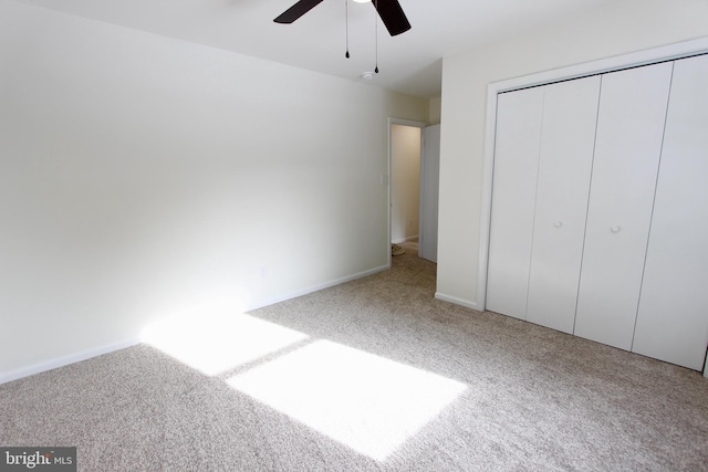 unfurnished bedroom featuring carpet floors, a closet, and ceiling fan