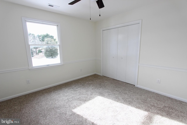 unfurnished bedroom with ceiling fan, carpet floors, and a closet