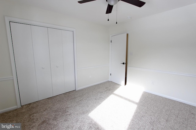 unfurnished bedroom featuring carpet floors, a closet, and ceiling fan