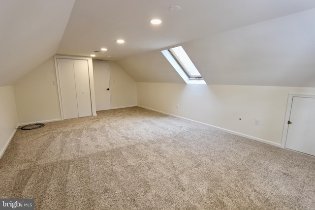 bonus room featuring carpet and vaulted ceiling with skylight