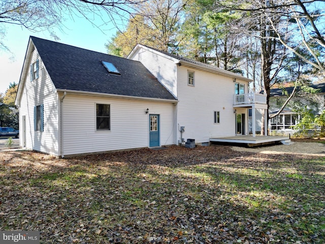 rear view of house featuring a wooden deck and a balcony