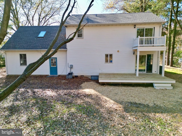 rear view of house featuring a wooden deck and a balcony