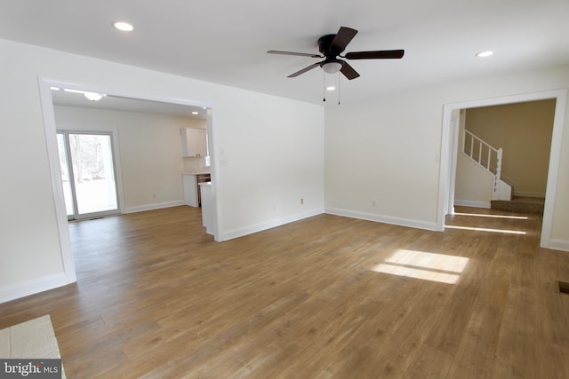 unfurnished living room with wood-type flooring and ceiling fan