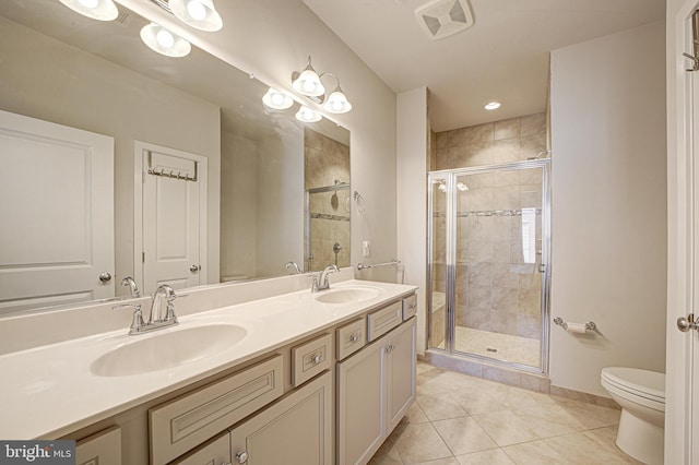 bathroom with vanity, a shower with door, tile patterned flooring, and toilet