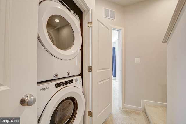 clothes washing area with stacked washer / dryer