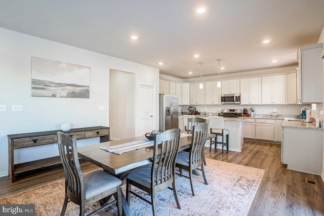 dining area featuring light wood-type flooring and sink