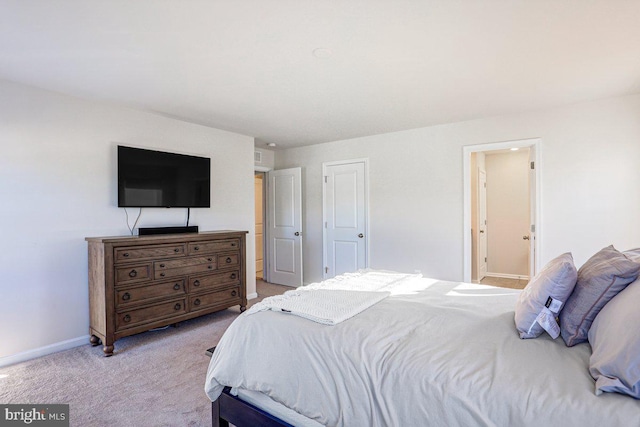 bedroom with light carpet and ensuite bath