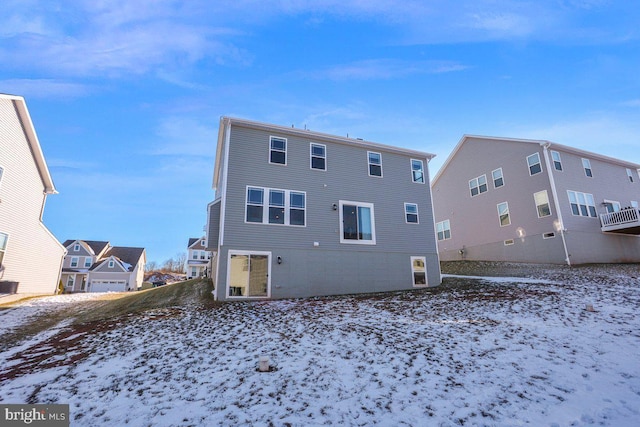 view of snow covered rear of property