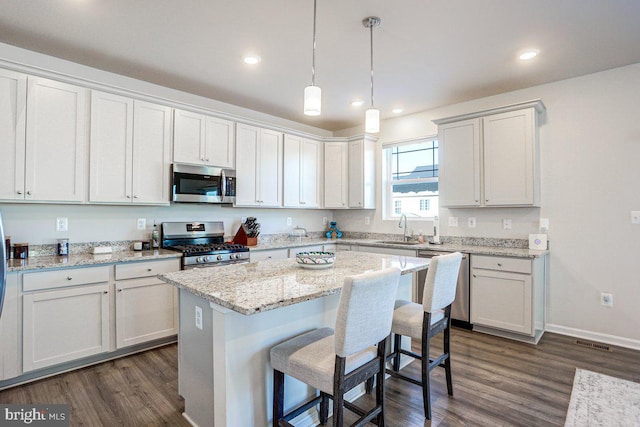 kitchen featuring white cabinetry, sink, pendant lighting, and appliances with stainless steel finishes