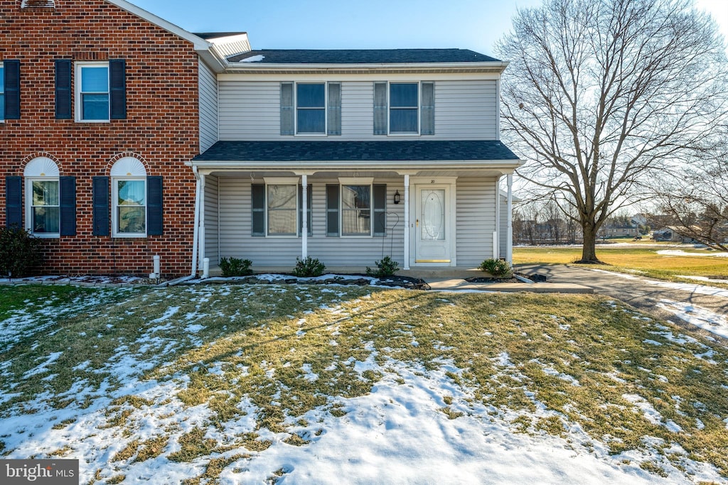 front facade featuring a yard and covered porch