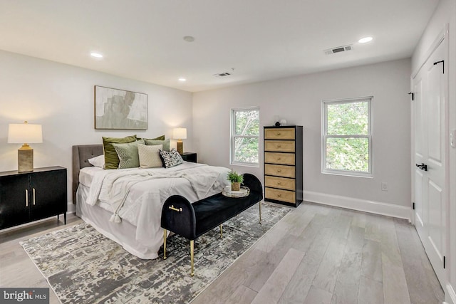 bedroom with light hardwood / wood-style flooring and multiple windows