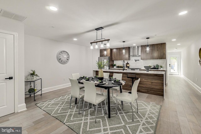 dining area with light wood-type flooring and sink