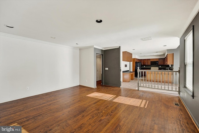 unfurnished living room with crown molding, a healthy amount of sunlight, and light hardwood / wood-style floors