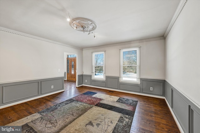 empty room featuring crown molding and dark hardwood / wood-style flooring