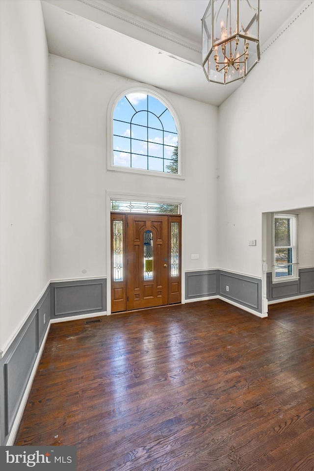 entryway with a healthy amount of sunlight, dark hardwood / wood-style floors, a chandelier, and a high ceiling