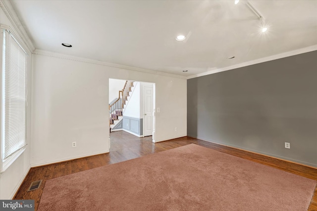 empty room featuring dark wood-type flooring and crown molding