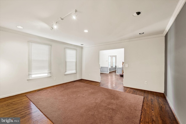 unfurnished room featuring dark wood-type flooring, ornamental molding, and rail lighting