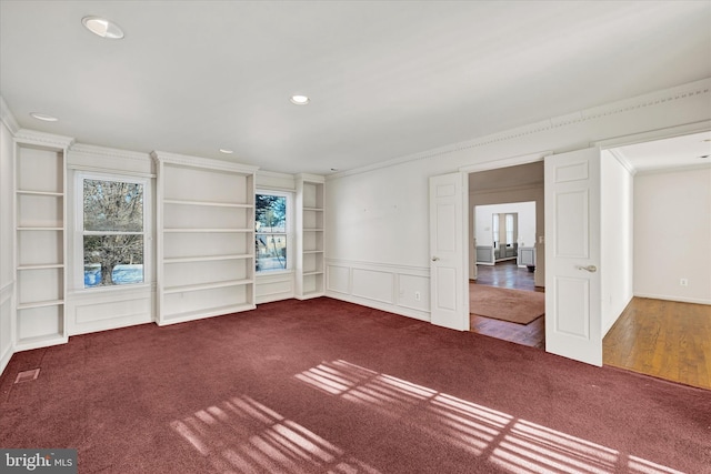 spare room with built in features, ornamental molding, and carpet