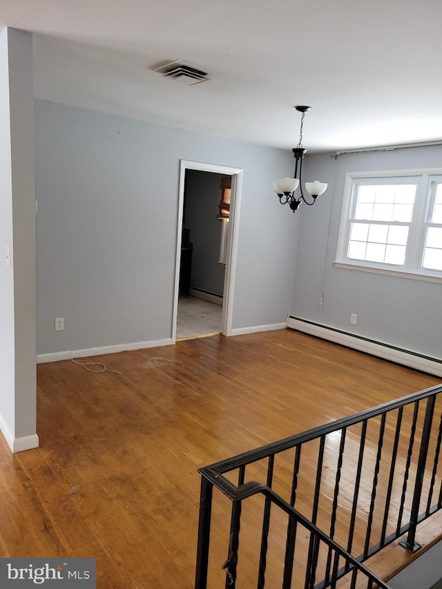 interior space featuring visible vents, a notable chandelier, wood finished floors, baseboards, and baseboard heating