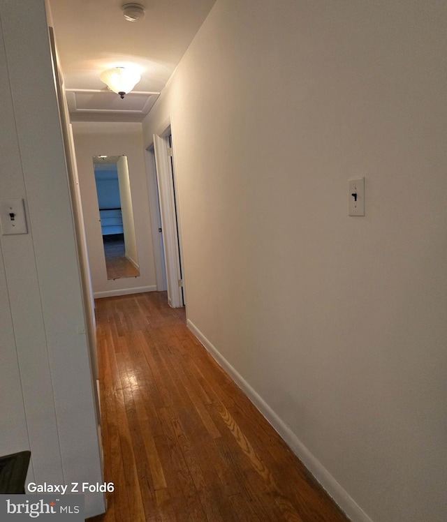 hall with hardwood / wood-style flooring and baseboards