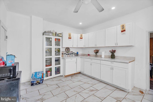 kitchen with ceiling fan and white cabinetry