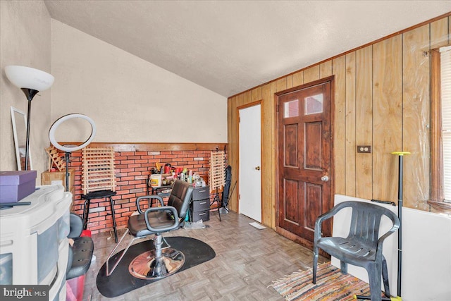 interior space featuring light parquet flooring, wood walls, and vaulted ceiling