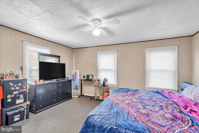 bedroom featuring a textured ceiling, wood walls, and ceiling fan