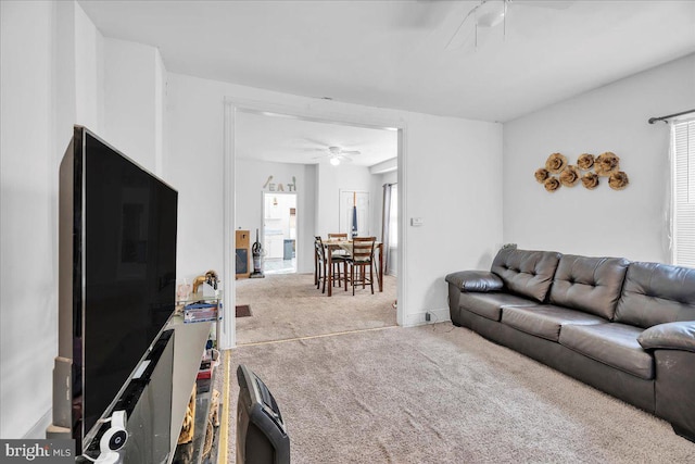 carpeted living room with ceiling fan