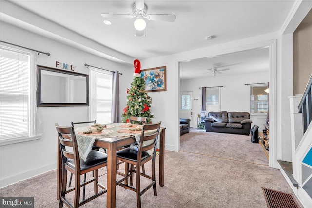 dining room with ceiling fan, plenty of natural light, and light colored carpet