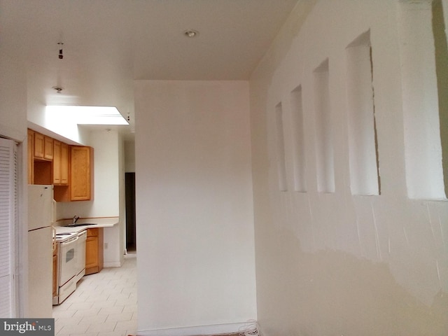 kitchen featuring white appliances and sink