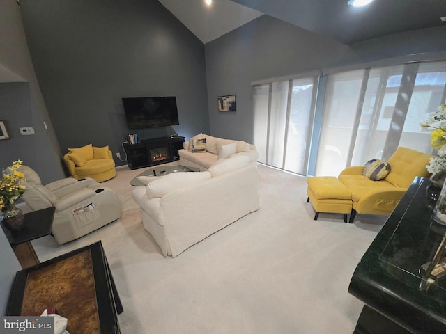 carpeted living room featuring high vaulted ceiling