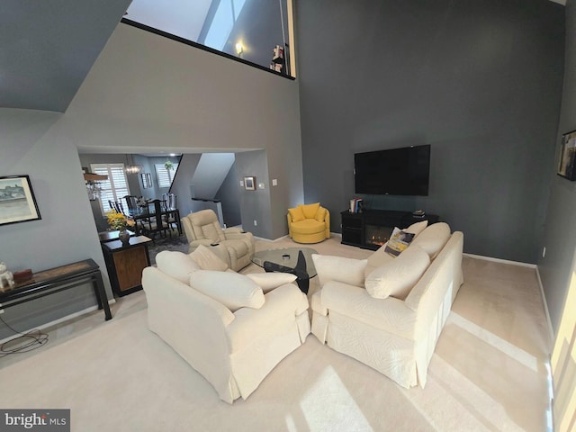 carpeted living room with vaulted ceiling and an inviting chandelier