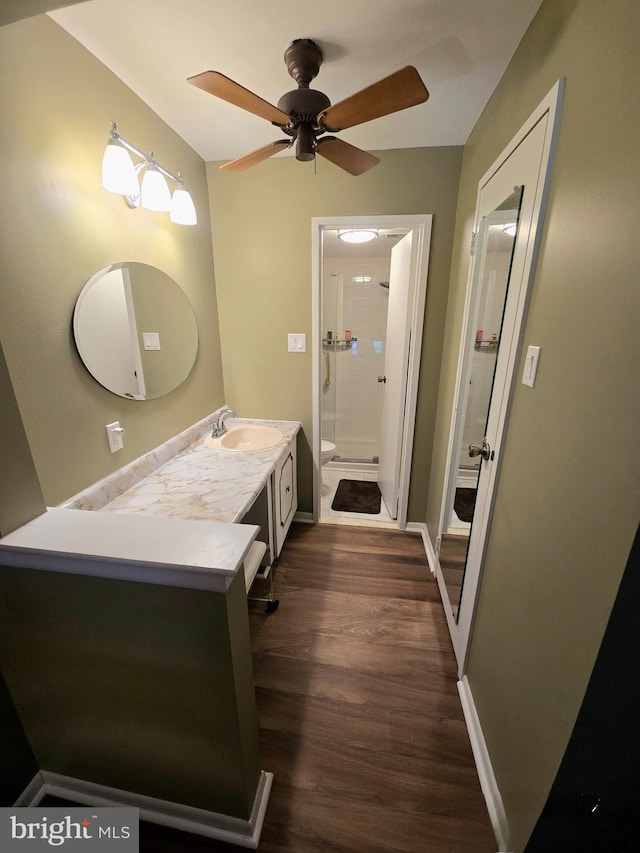 bathroom featuring vanity, a shower, hardwood / wood-style flooring, ceiling fan, and toilet