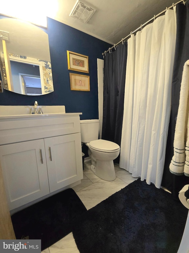 bathroom with curtained shower, vanity, and toilet