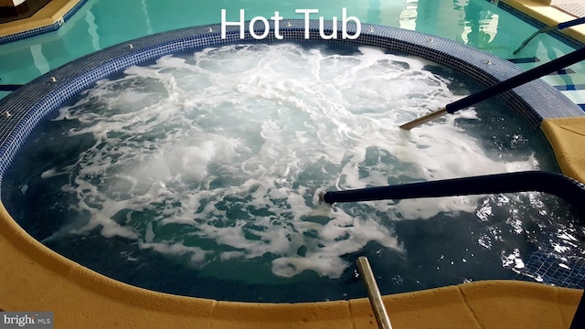 view of swimming pool with a hot tub