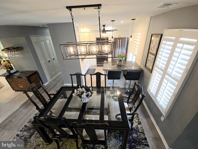 dining space with hardwood / wood-style floors, ceiling fan, and lofted ceiling