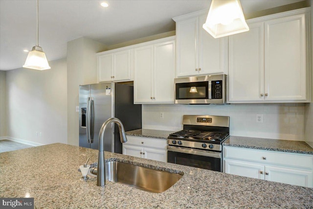 kitchen featuring backsplash, appliances with stainless steel finishes, sink, and white cabinets