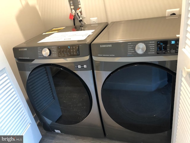 laundry area featuring wood-type flooring and washer and clothes dryer