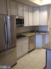 kitchen with light tile patterned floors, sink, and appliances with stainless steel finishes