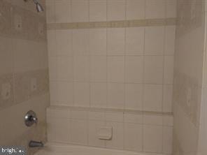 interior details with tiled shower / bath combo